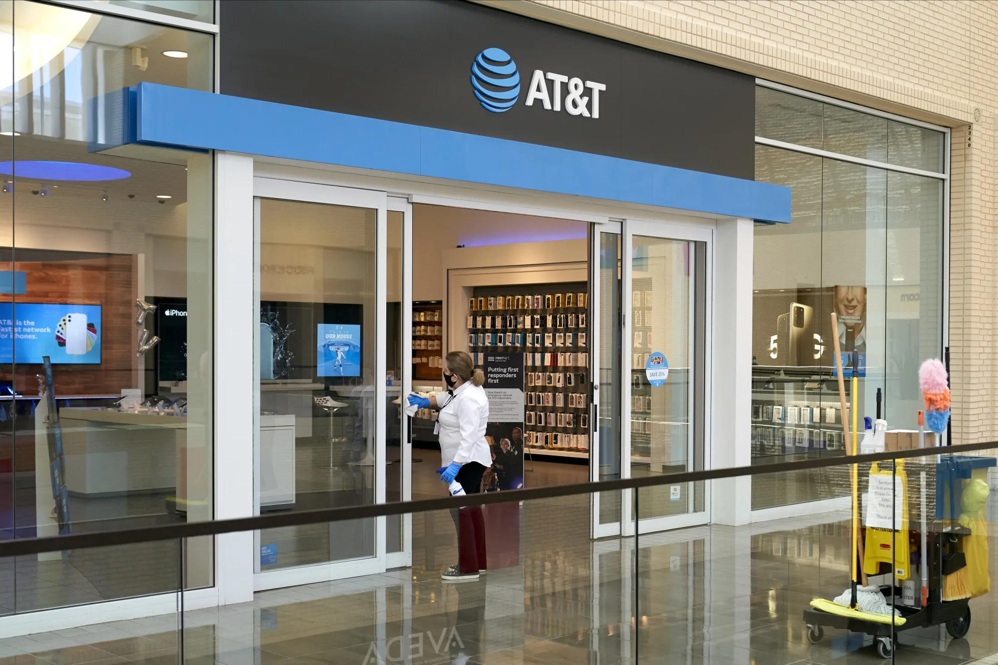 A worker disinfects the doors of an AT&T store at a mall in Dallas on May 1.