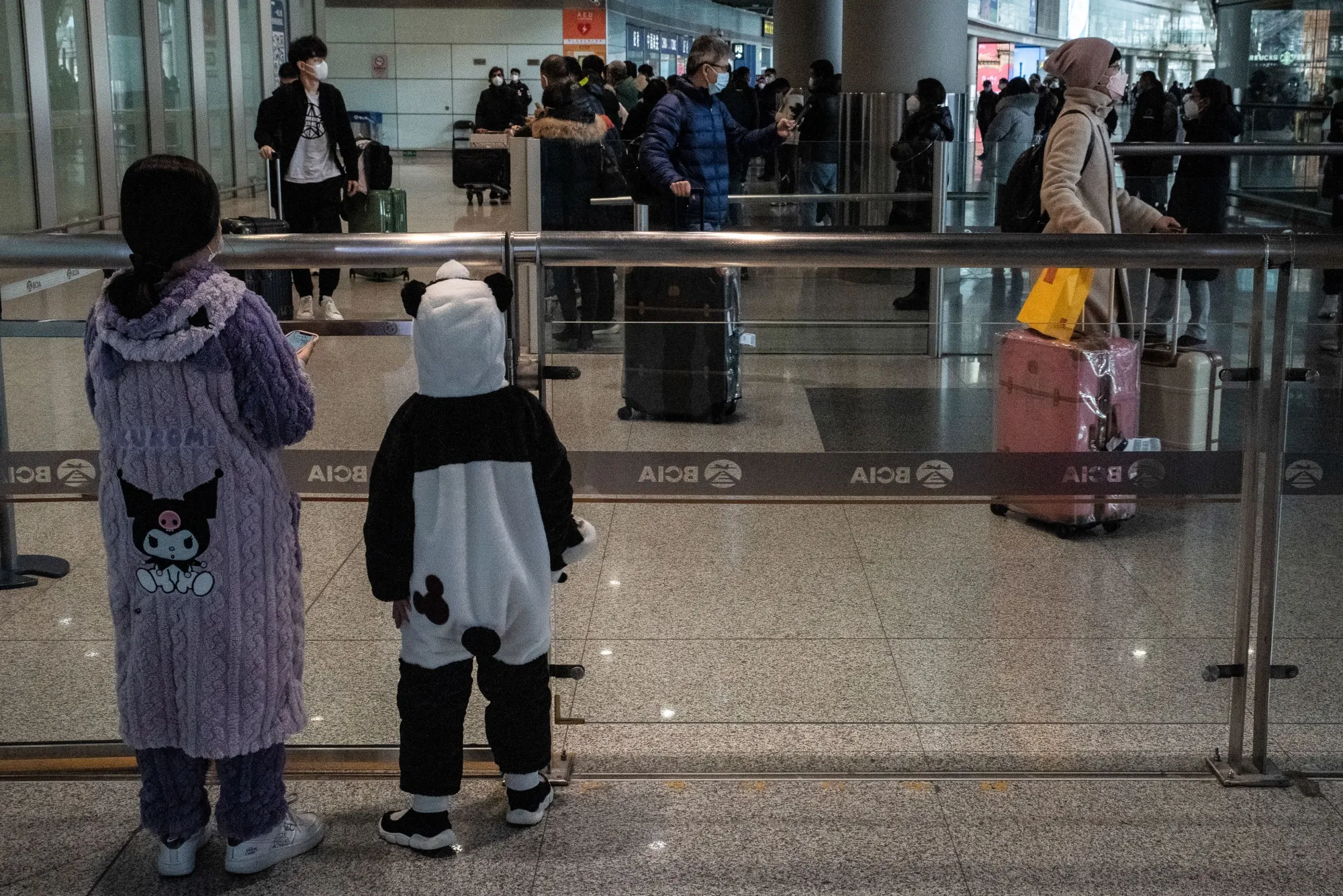 Two children wait for a relative in the arrival hall for international flights at Beijing Capital Airport on Jan. 8.