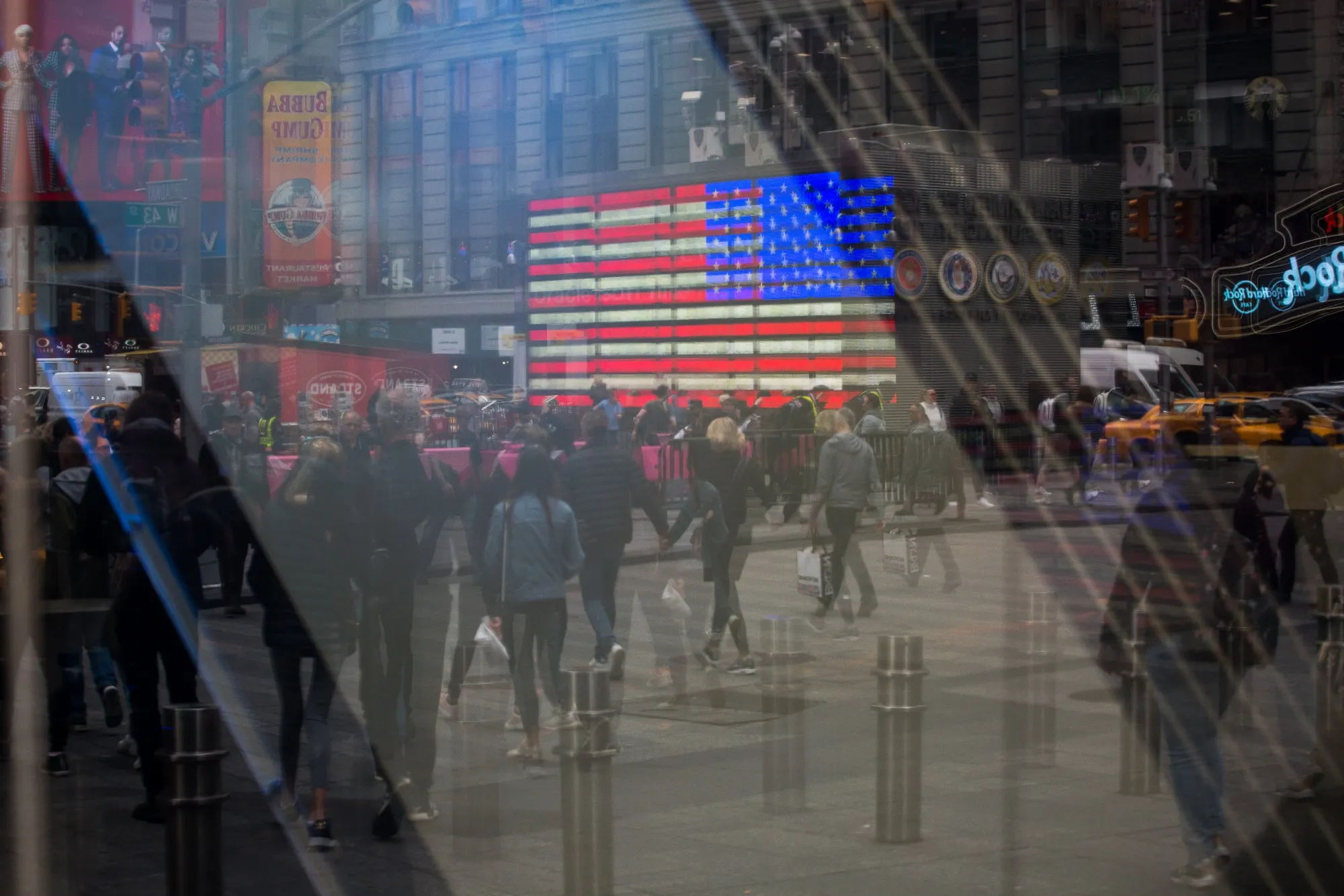 Pedestrians are reflected in a window of the Nasdaq MarketSite.