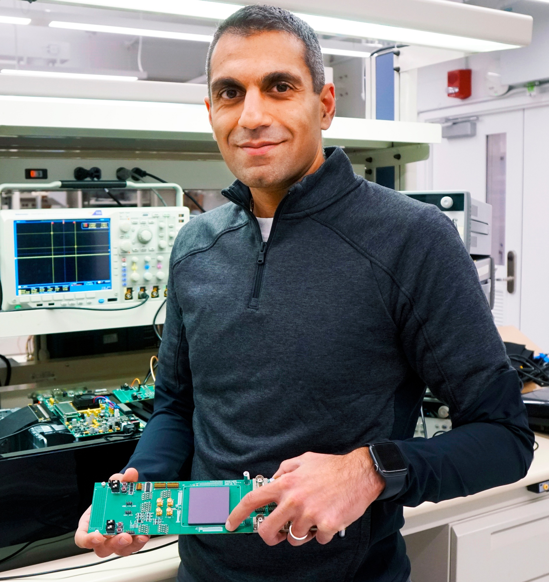 EnCharge AI co-founder and CEO Naveen Verma holding a prototype switched-capacitor analog in-memory computing chip at his research lab at Princeton University.