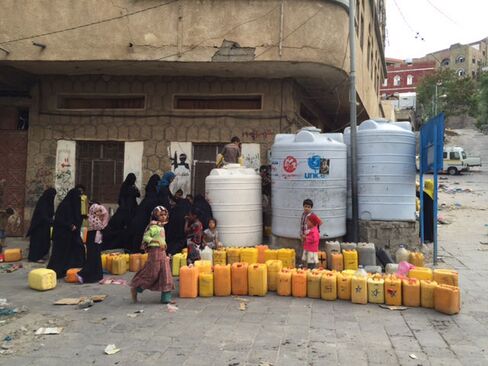 Taiz residents line up to receive water distributed by charities.
