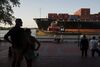 Pedestrians watch from River Street as a cargo ship and a tug boat travel into the Port of Savannah on the Savannah River in Savannah, Georgia, U.S., on Saturday, Aug. 15, 2015. Savannah, the oldest city and third-largest metropolitan area in Georgia, attracts millions of visitors to its cobblestone streets, parks, and notable historic buildings.