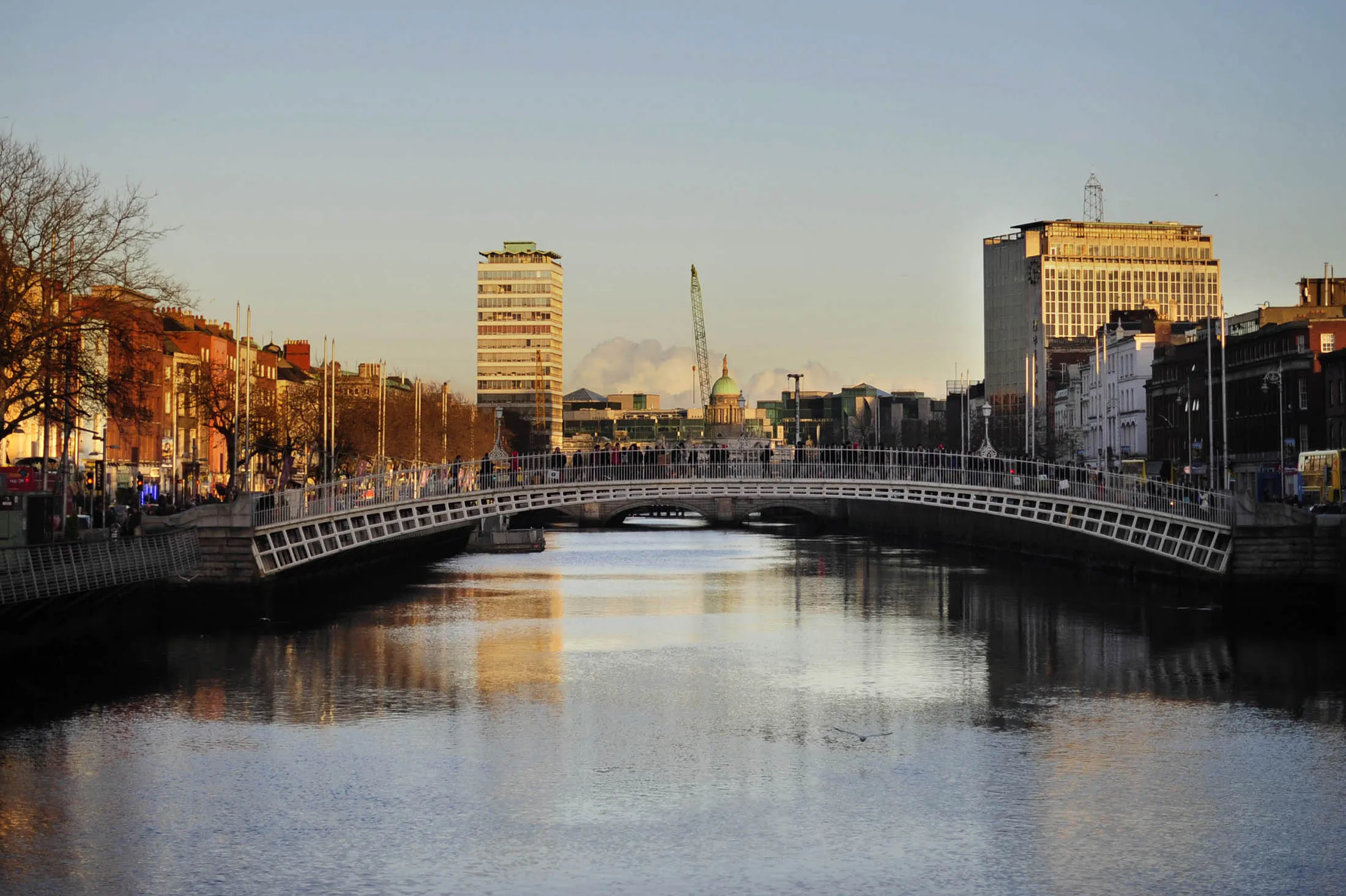 A seagull flies over the River Iffey in front of the Ha'penny Bridge in Dublin, Ireland, on Saturday, Dec. 1, 2012. Ireland's Finance Minister Michael Noonan will deliver the country's 2013 budget on Dec. 5, and is expected to cover taxation measures and spending details, according to a spokeswoman at the Finance Ministry. Photograph: Aidan Crawley/Bloomberg
