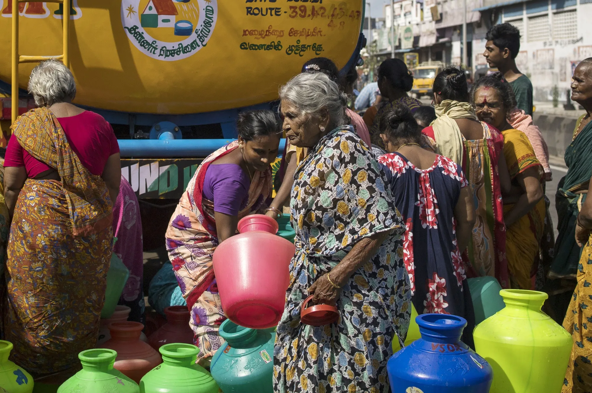Residents wait in line to fill pots from a water truck in Chennai, India, in 2021.