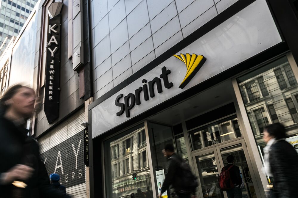 Pedestrians pass in front of a Sprint Corp. store in New York, U.S. on Monday, April 30, 2018.