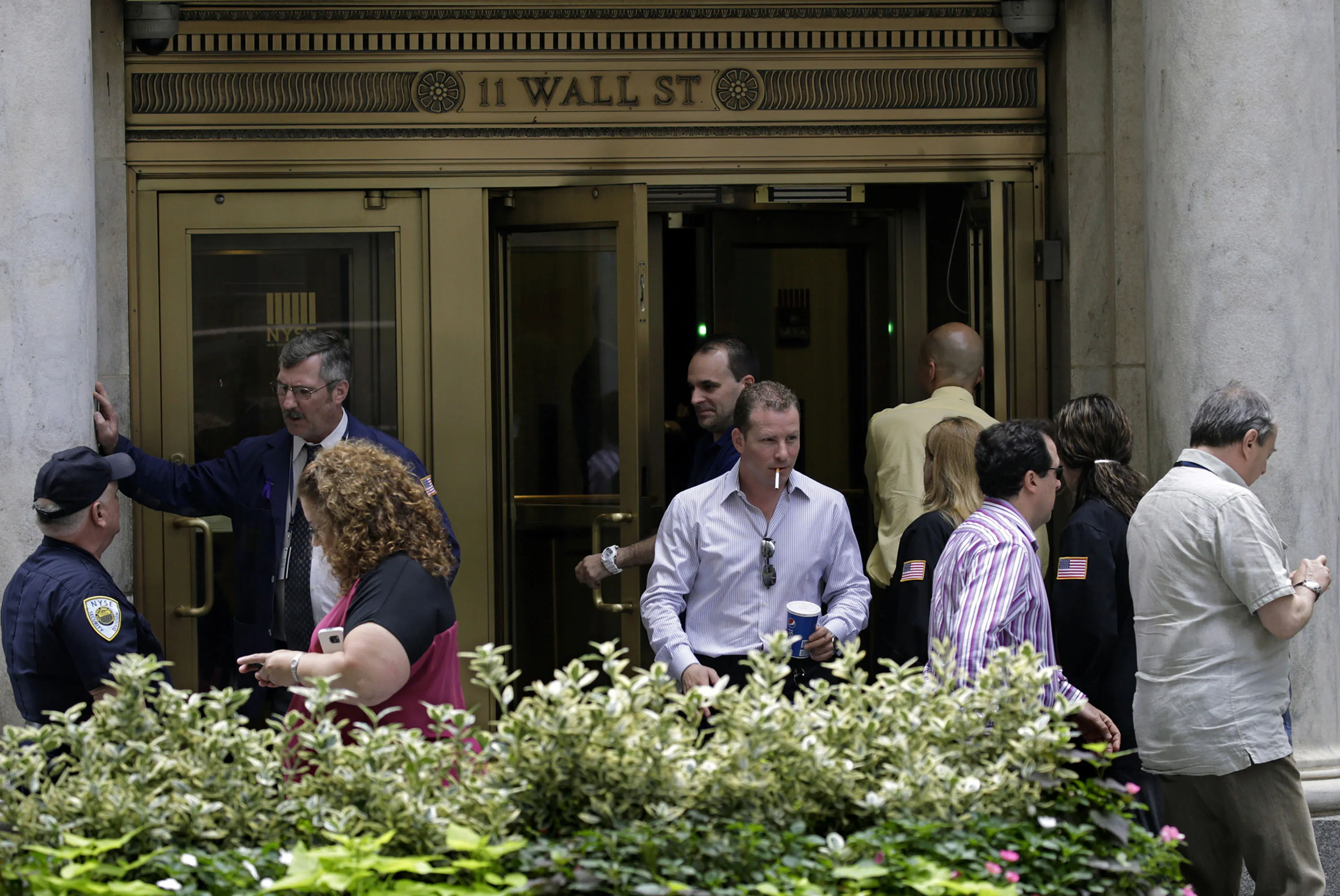 People exit the New York Stock Exchange on July 8 following the shutdown.
