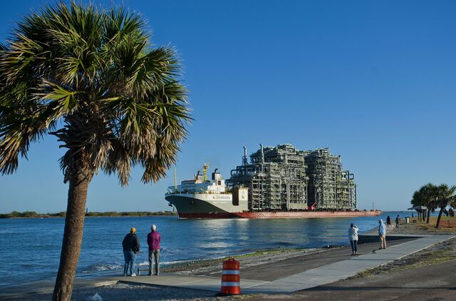 People watch as a cargo ship carrying a furnace travels to the Port of Corpus Christi in Corpus Christi, Texas, U.S., on Sunday, Dec. 27, 2020. The multi-story furnace will be used for a $10 billion petrochemical plant being built by Gulf Coast Growth Ventures, a joint project by ExxonMobil and SABIC.
