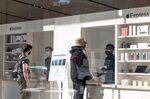 Employees assist customers an Apple store in San Francisco on Feb. 17. 