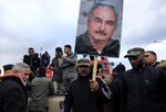 People raise a picture of Libyan strongman Khalifa Haftar as they take part in a demonstration in the Libyan city of Benghazi on Jan. 3, 2020.