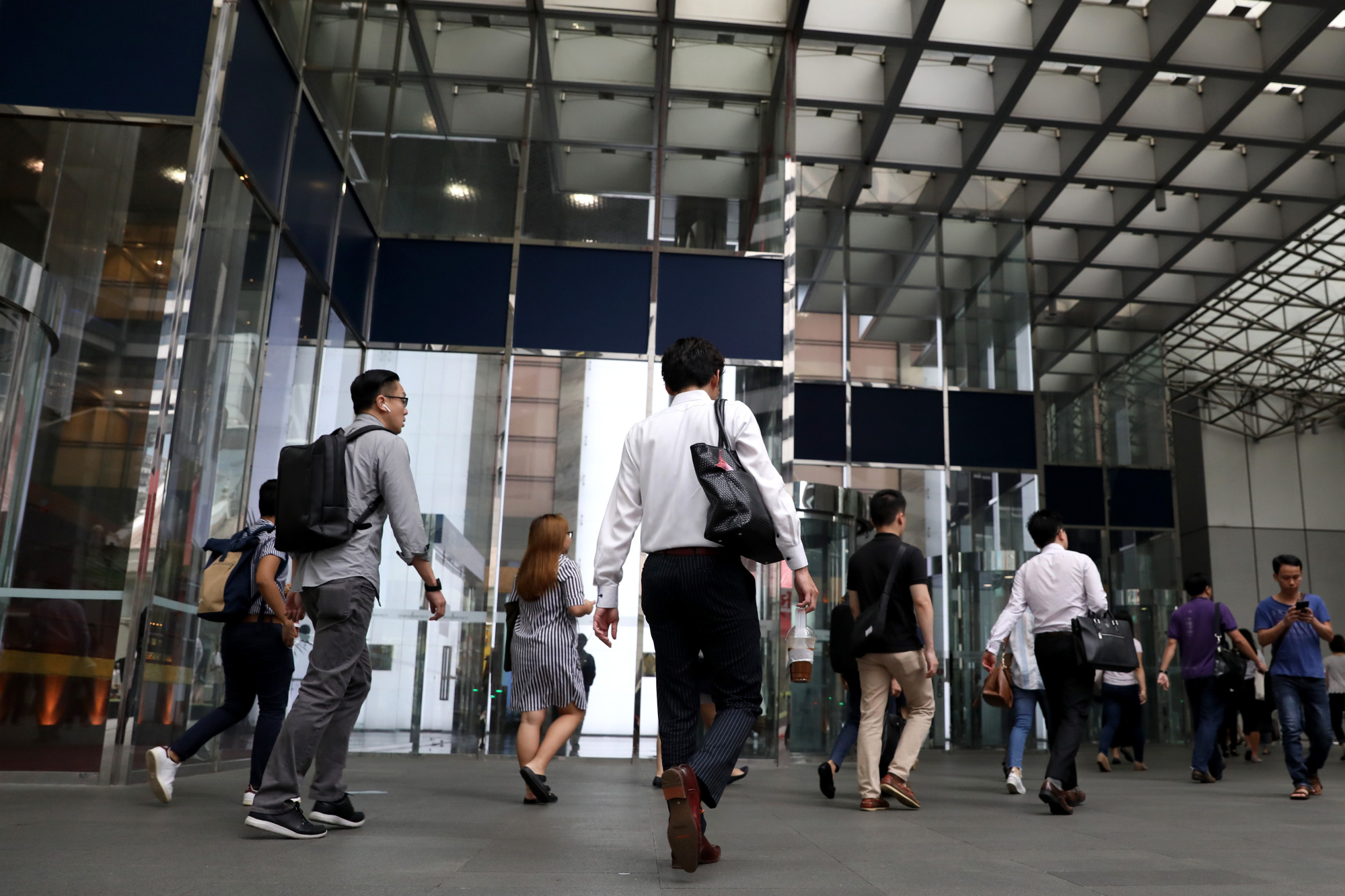 Pedestrians walk past an office tower in the central business district in Singapore.
