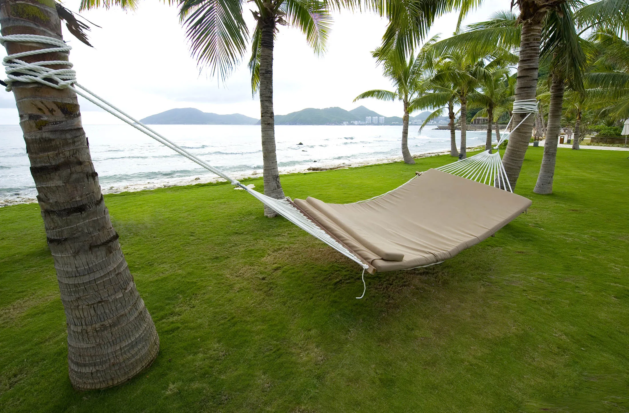 SANYA, CHINA - August 15: A hammock awaits guests in the Mandarin Oriental hotel resort on the on the Dadonghai bay, coast of Sanya on August 15, 2010 in Hainan province, China. Sanya is the southernmost city of Hainan island, located in the Southern Chinese Sea. Sometimes referred to as the Hawaii of China because of its tropical climate, palm trees and white-sand beaches, Sanya is a booming tourism destination.
