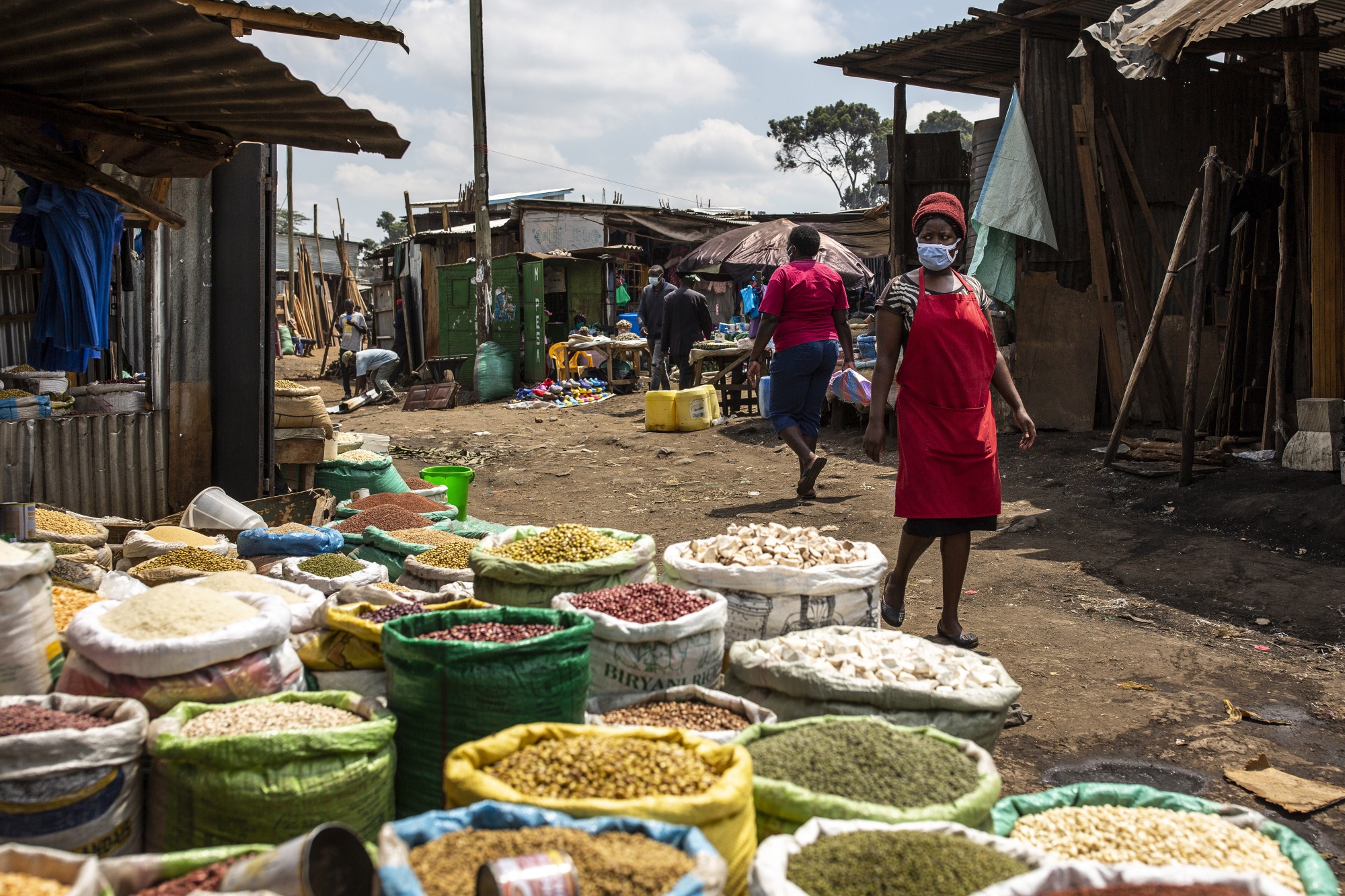 A vendor&nbsp;walks by bags of beans and pulses for sale at Toi market in Nairobi, Kenya.