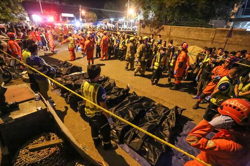 Rescue workers gather bags containing the bodies of victims at a night market in Davao City on Sept. 3.