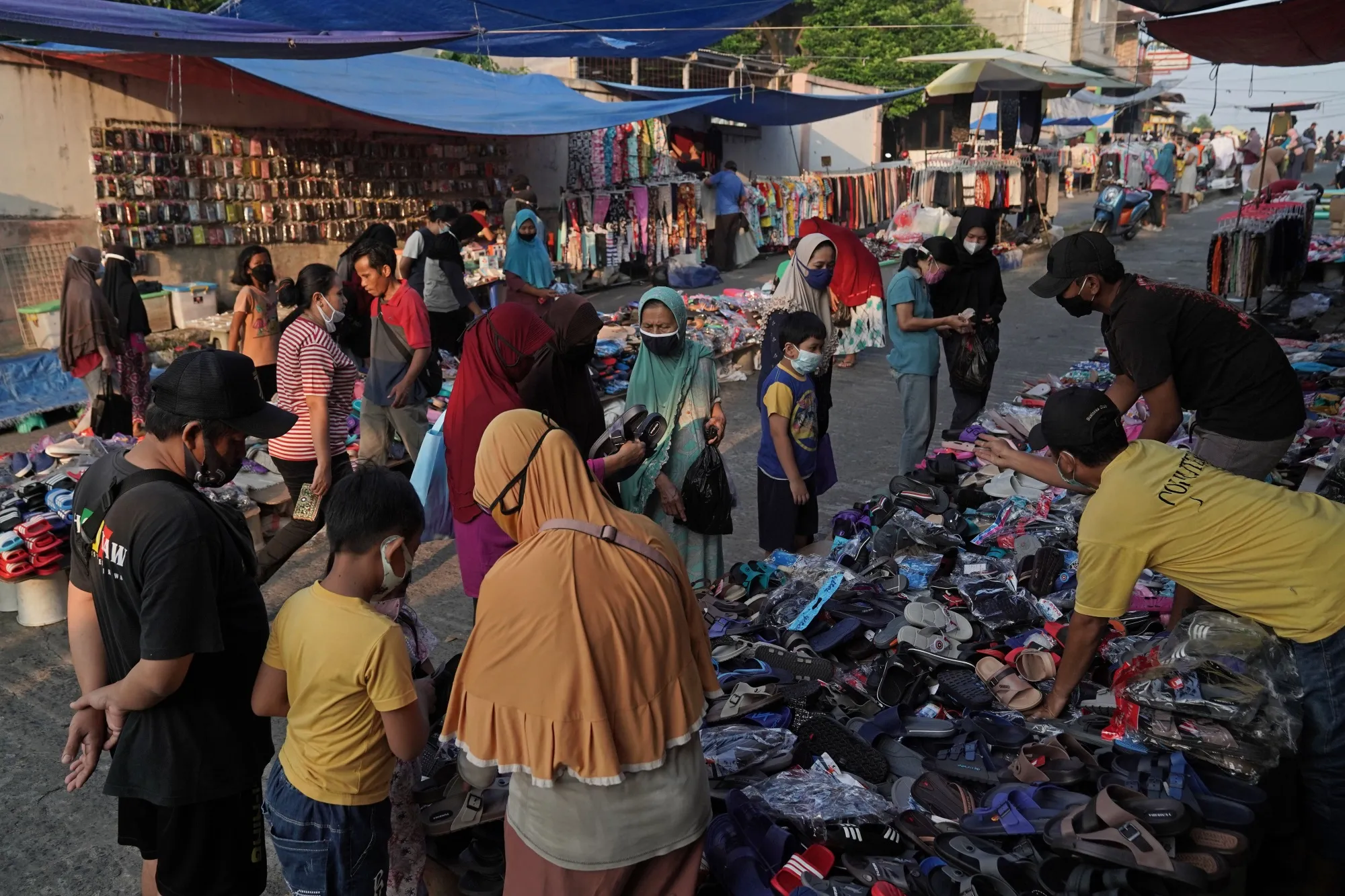 Shoppers look at shoes and sandals a market in Jakarta, Indonesia.