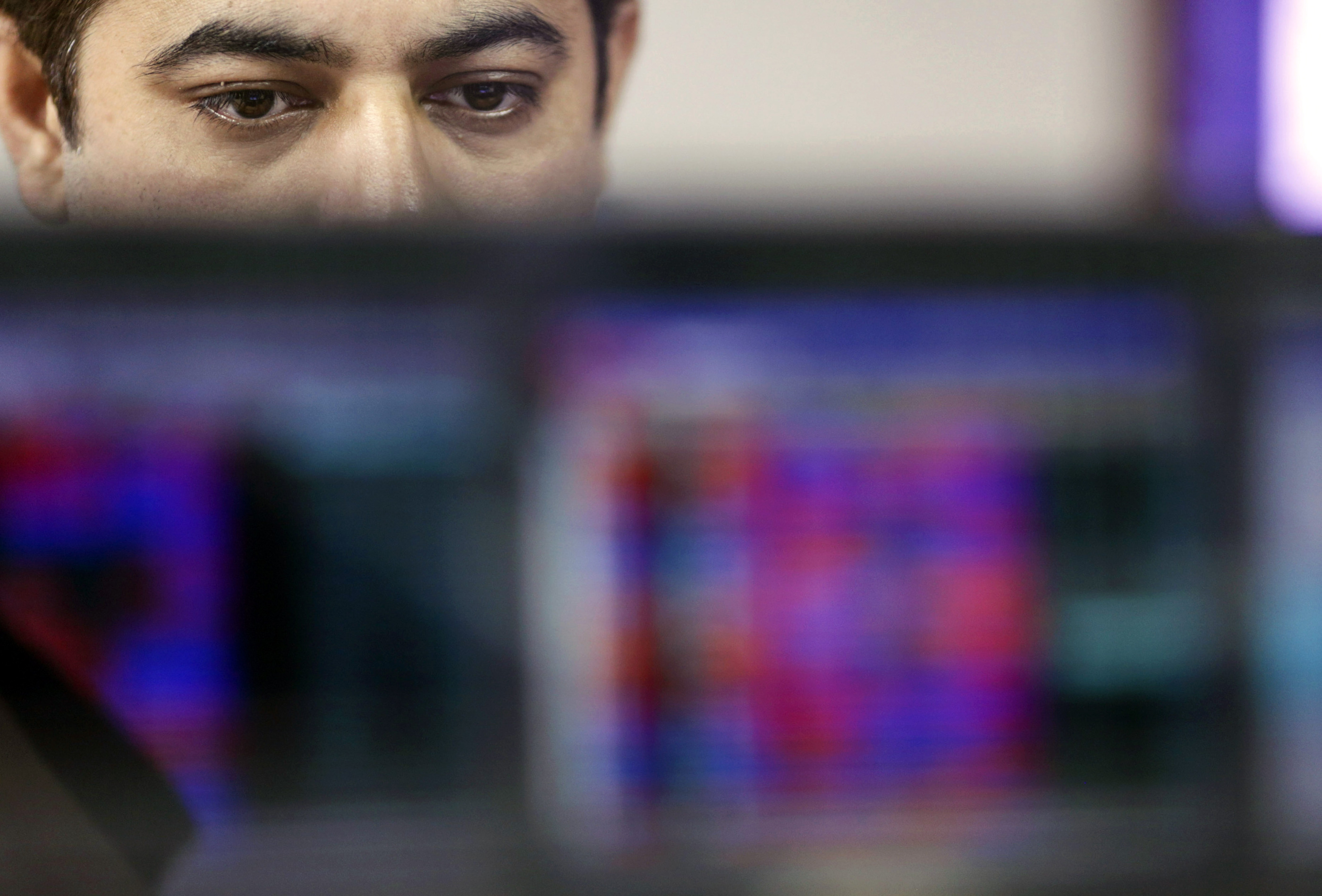 An employee monitors securities on a computer monitor at a brokerage firm in Mumbai, India, on Tuesday, Aug. 25, 2015. Indian stocks advanced in volatile trading a day after the benchmark gauge plunged the most in six years, as banks helped counter declines in software exporters.