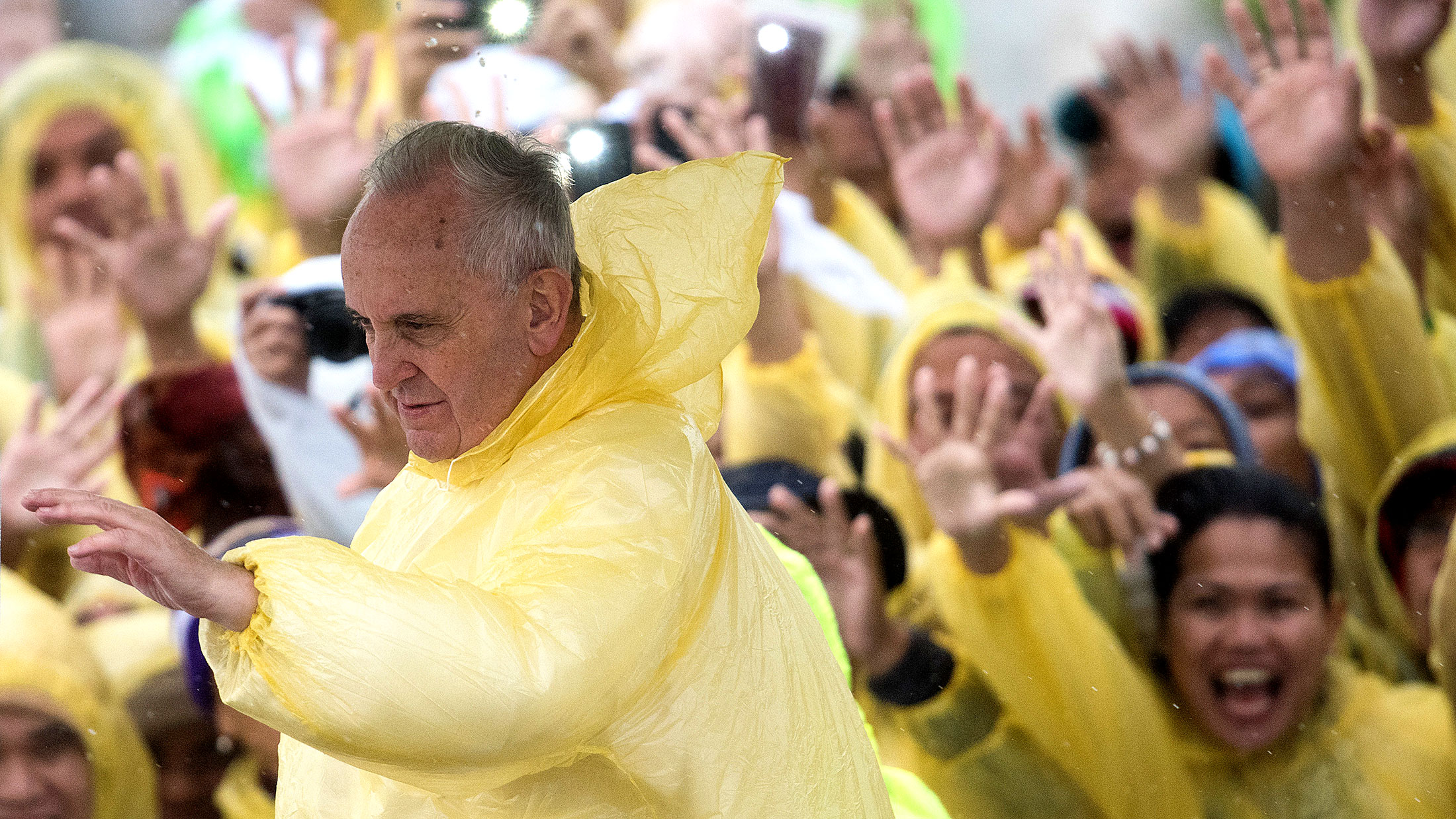 Pope Francis wears a plastic poncho as he waves to well-wishers after a mass in the Philippine city of Tacloban on Jan. 17, 2015.
