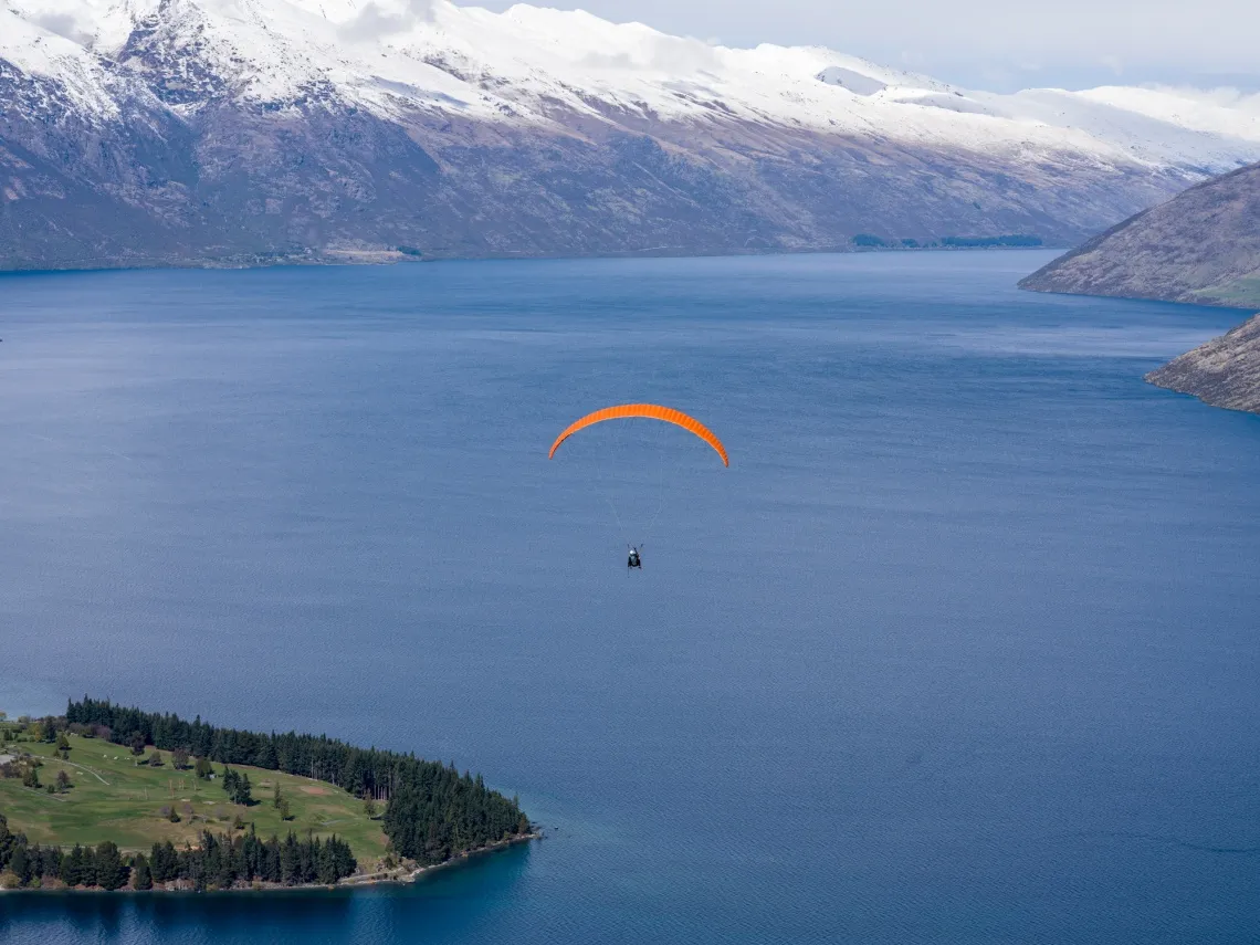 Skydivers above Lake Wakatipu in Queenstown, New Zealand.