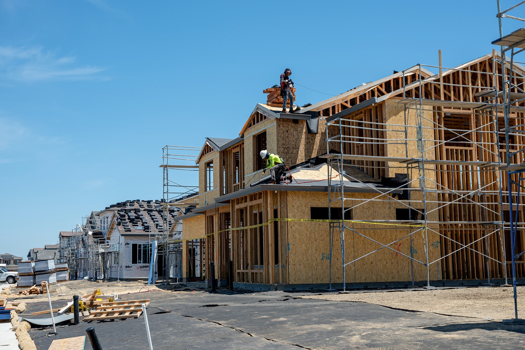 Workers install roofing on a home under construction in Vacaville, California.