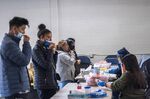 Residents take a self administered Covid-19 swab test at a testing site in Sacramento, California, on Jan. 12.