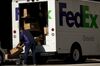 A FedEx Corp. worker wearing a protective mask unloads a truck in downtown Dallas, Texas, U.S..
