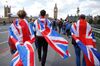 People walk over Westminster Bridge wrapped in Union flags.