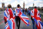 People walk over Westminster Bridge wrapped in Union flags.