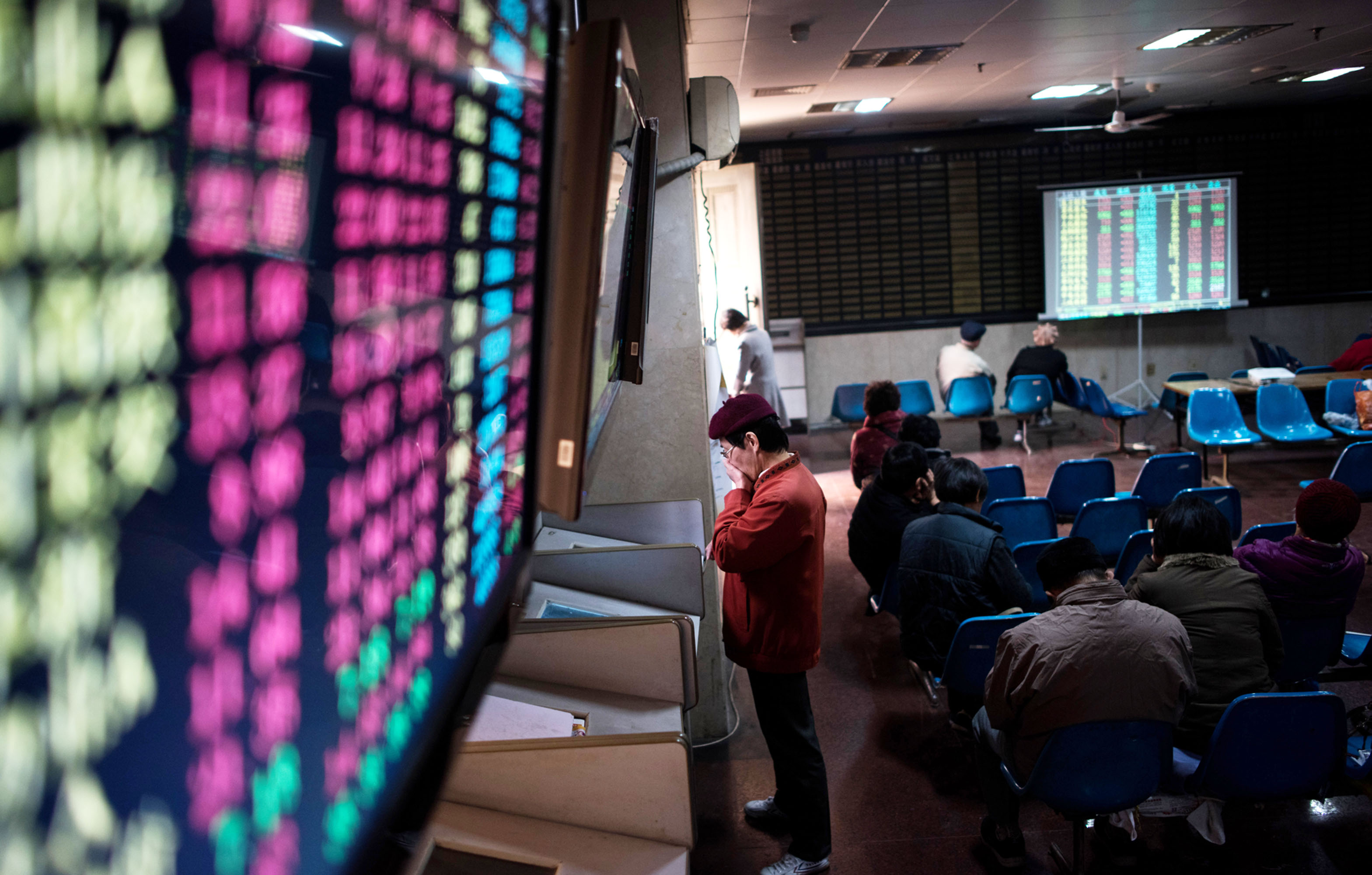 An investor monitors screens showing stock market movements at a brokerage house in Shanghai.&nbsp;