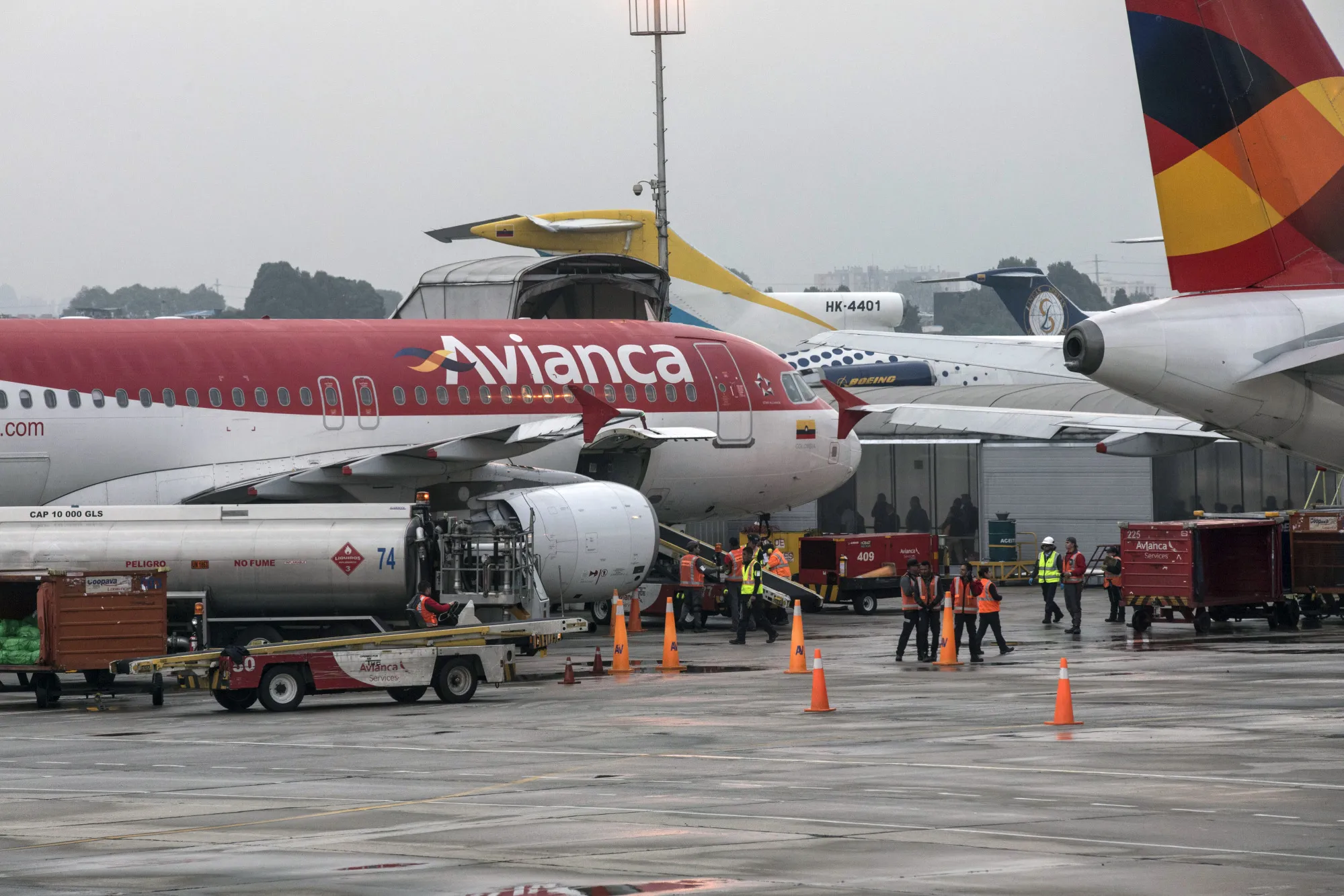 Ground crew members unload luggage from an Avianca Holdings SA passenger airplane.