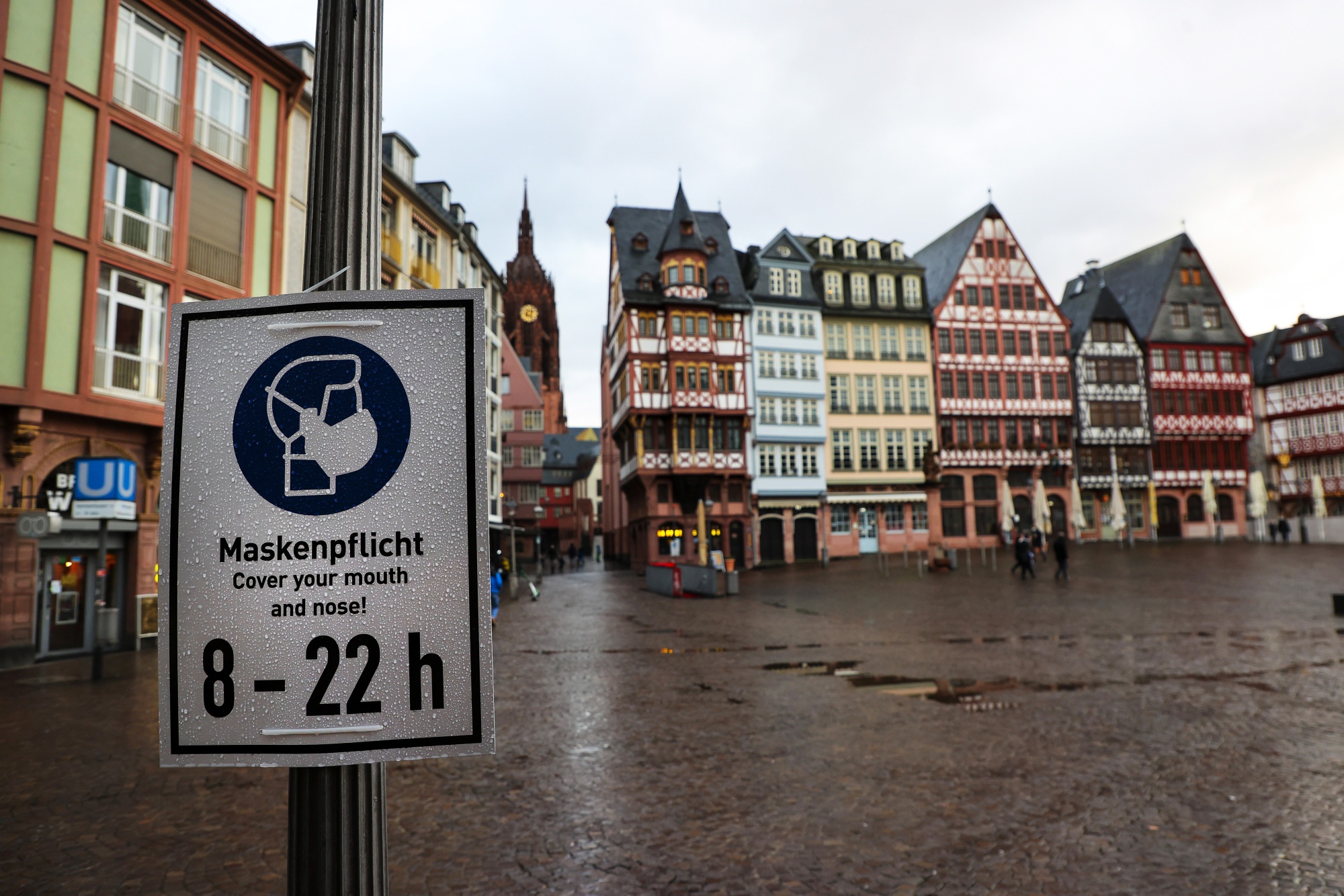 A protective face mask sign in Romerberg Square in Frankfurt.