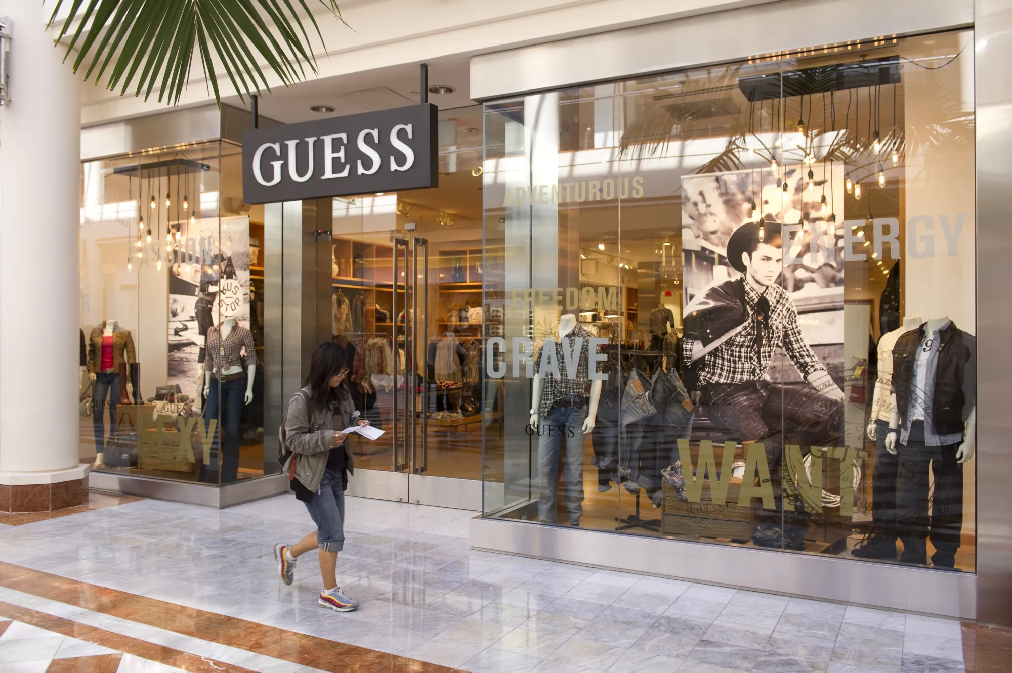 A shopper passes a Guess Inc. store in San Francisco.
