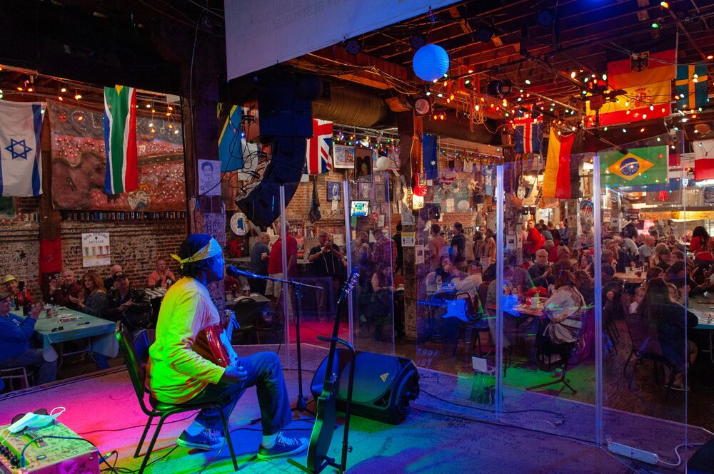 A musician performs behind plexiglass inside a venue at the Juke Joint Festival in Clarksdale, Mississippi.