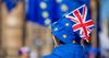 An anti-Brexit protester wears a Union Flag, also known as a Union Jack, on a hat in the colors of the European Union (EU) flag, while standing near the Houses of Parliament in London.