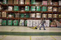 A volunteer moves a pallet jack after hauling completed Family Food Boxes at a Midwest Food Bank distribution warehouse in Normal, Illinois.