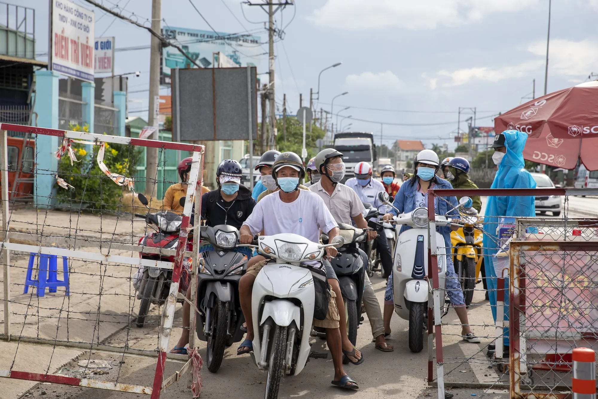 Motorcyclists wait at a Covid-19 border checkpoint in Ho Chi Minh City, Vietnam.