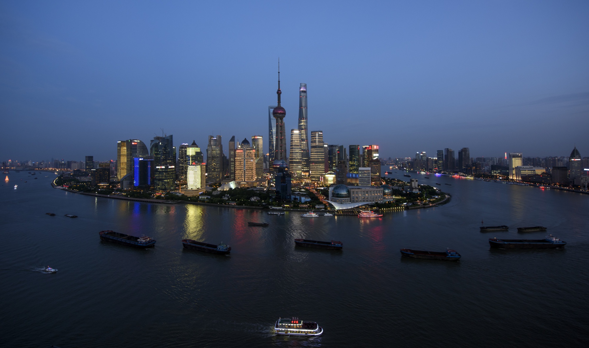 Ships pass by the skyline of the Lujiazui Financial District in Pudong in Shanghai.