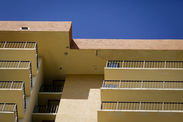 looking upward at yellow balconies, with some peeling paint