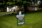 A real estate sign stands outside a home for sale in Peoria, Illinois, U.S.