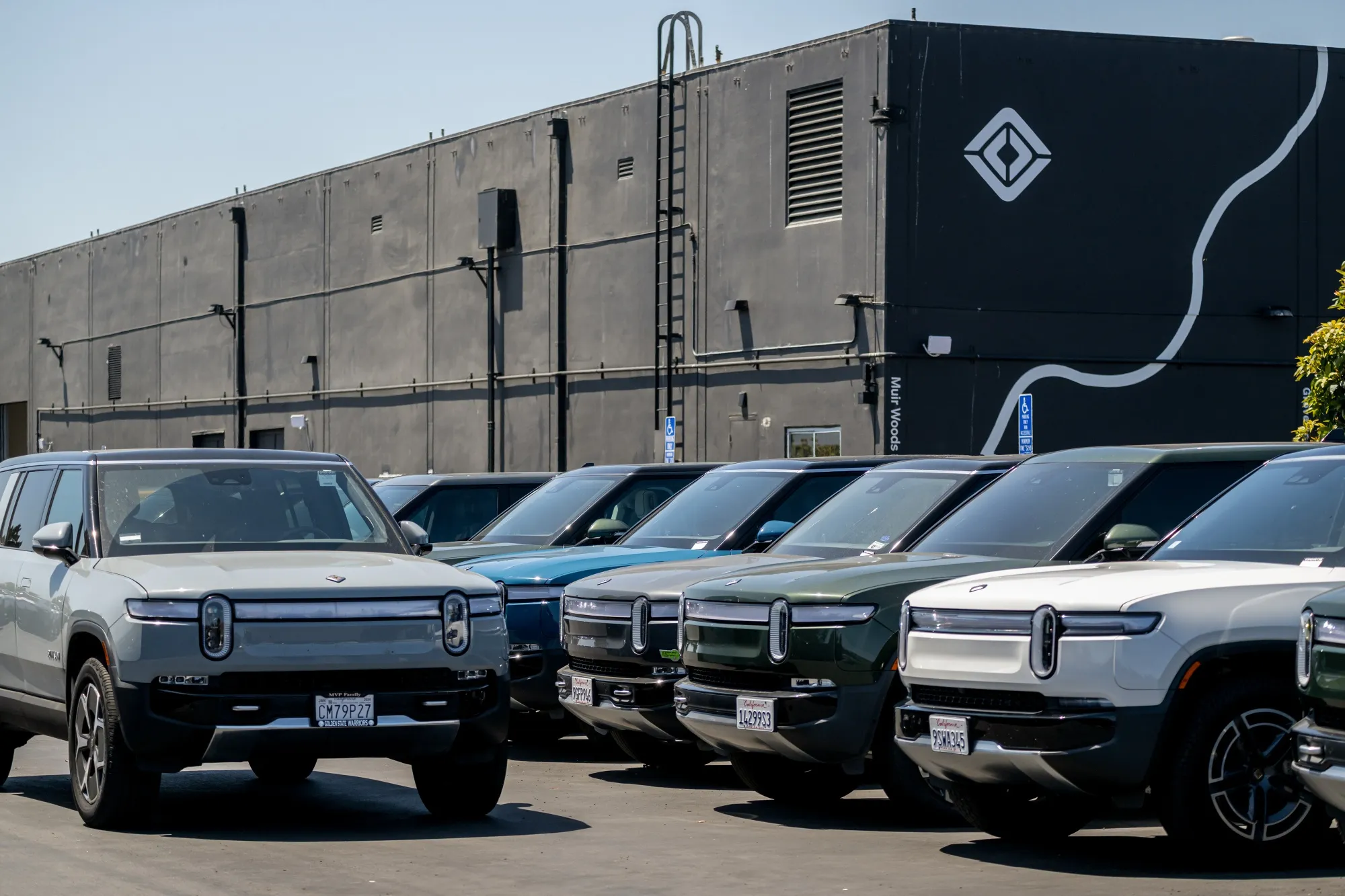 Rivian R1S and R1T electric vehicles at a dealership and service center in San Francisco.