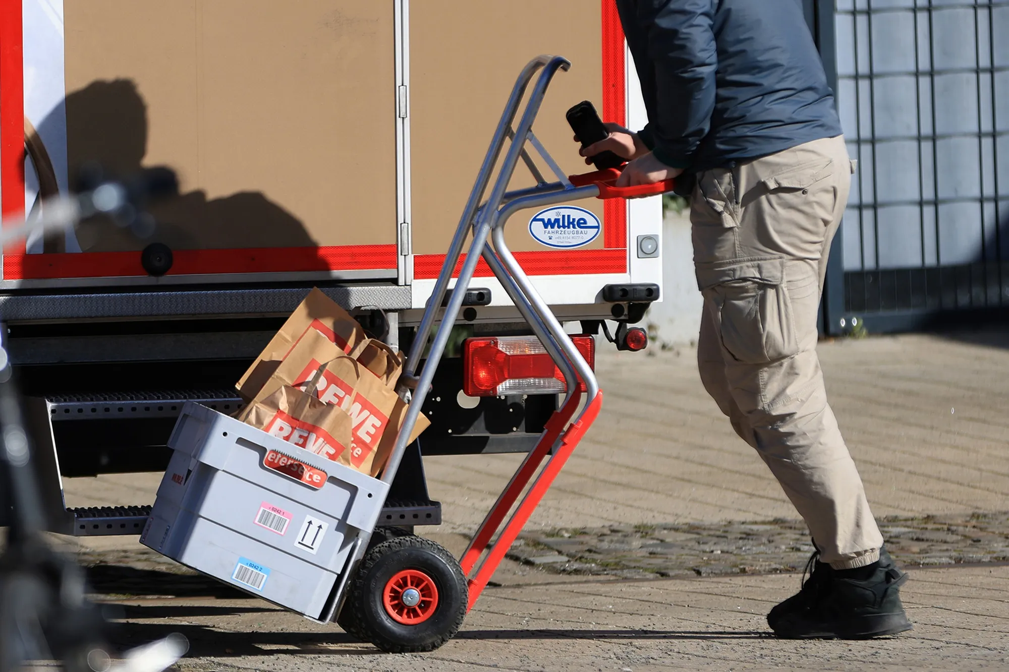 A delivery driver for a supermarket unloads from a truck in Berlin.