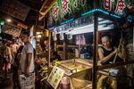 Pedestrians walk past a vendor preparing food at a night market stall in Taipei, Taiwan, on Saturday, July 16, 2016. Taiwan is scheduled to release gross domestic product (GDP) figures on July 29.
