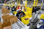 Amazon employees load boxes at the company’s fulfillment center in Tracy, Calif., on Nov. 30