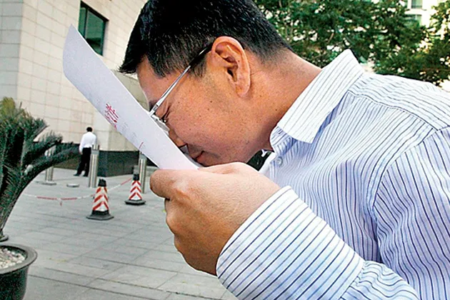 An official in Guangdong kisses a document approving an $11 billion steel plant