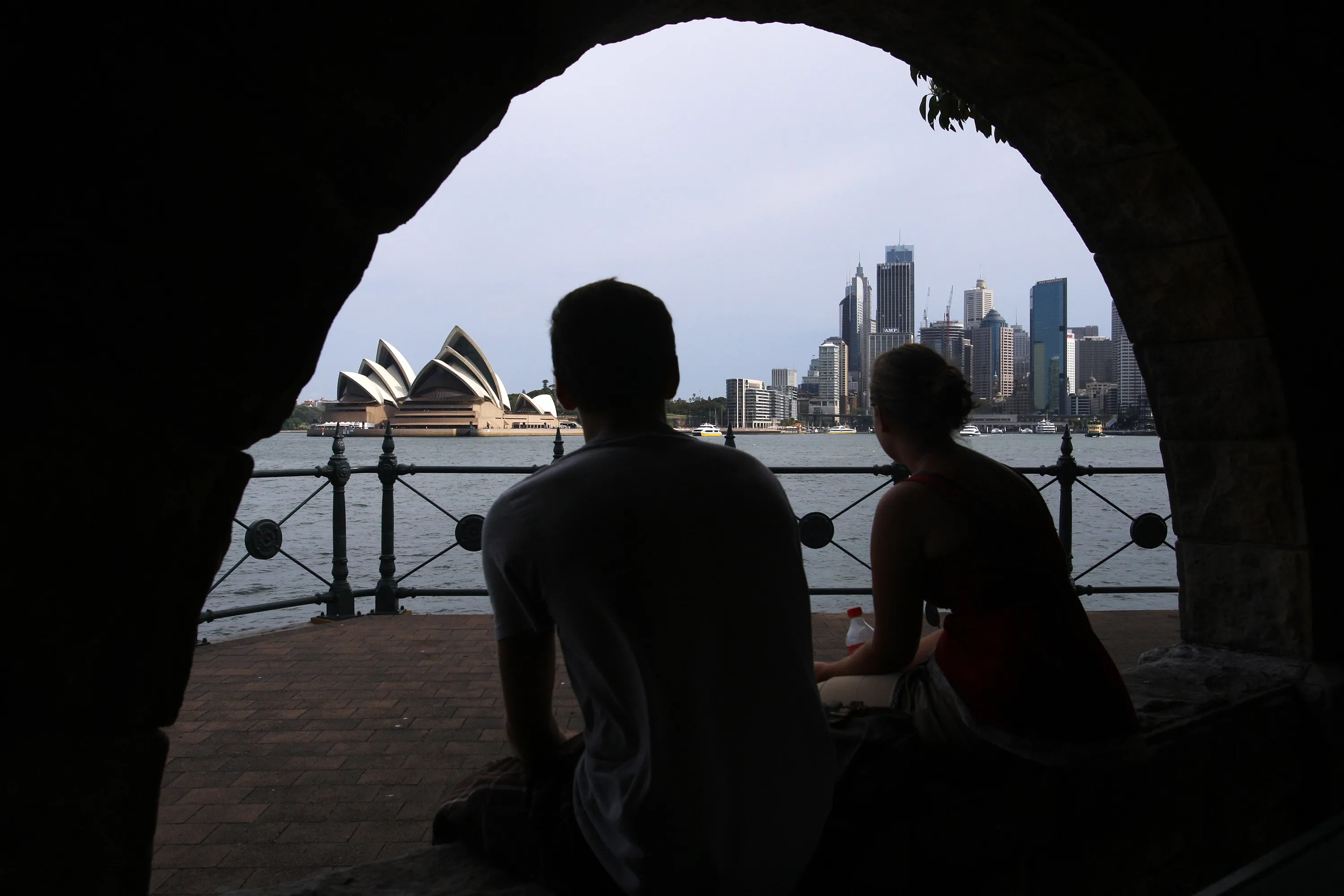A couple view the Sydney Opera House and city skyline in Sydney, Australia.