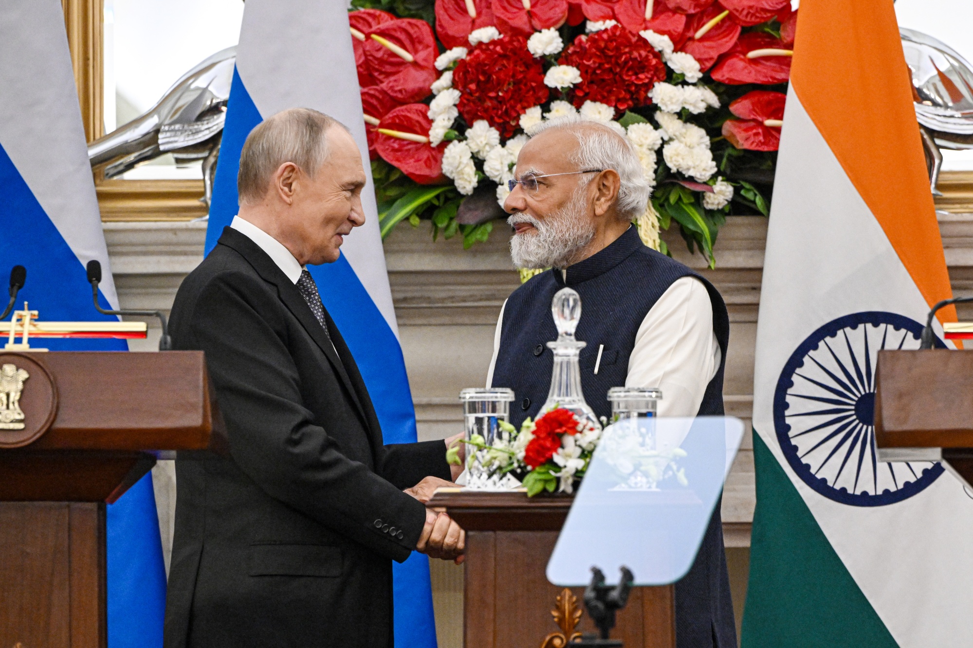 Vladimir Putin, Russia's president, left, shakes hands with Narendra Modi, India's prime minister, during a news conference at Hyderabad House in New Delhi, India, on Friday, Dec. 5, 2025. Modi and Putin held a bilateral meeting in New Delhi, as the two leaders look to deepen economic cooperation in the face of pressure from US President Donald Trump. Photographer: Prakash Singh/Bloomberg