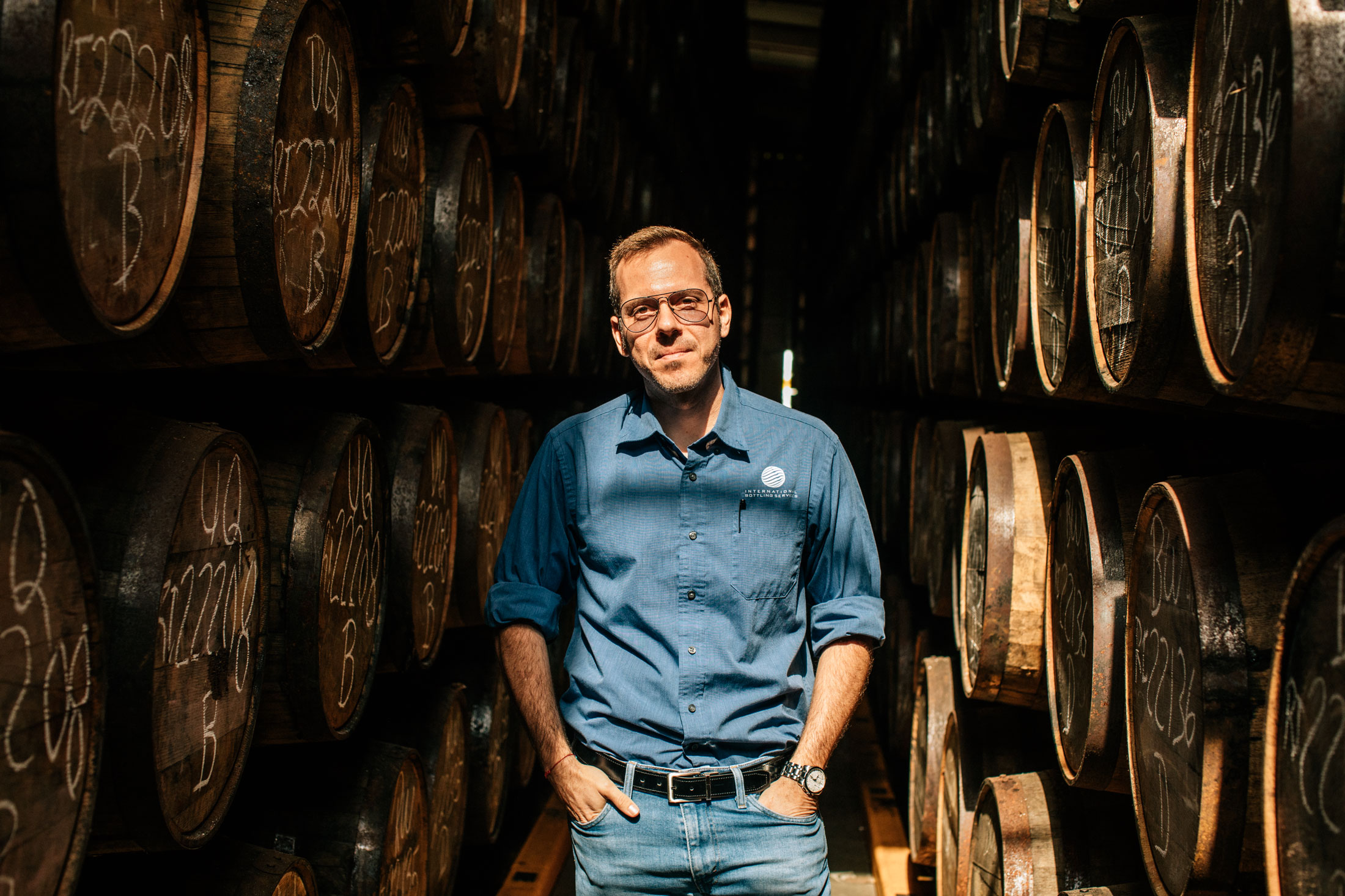 Gian Guido Arditi at the Ron Diplomático facility in Panama City, standing by barrels of aging rum.