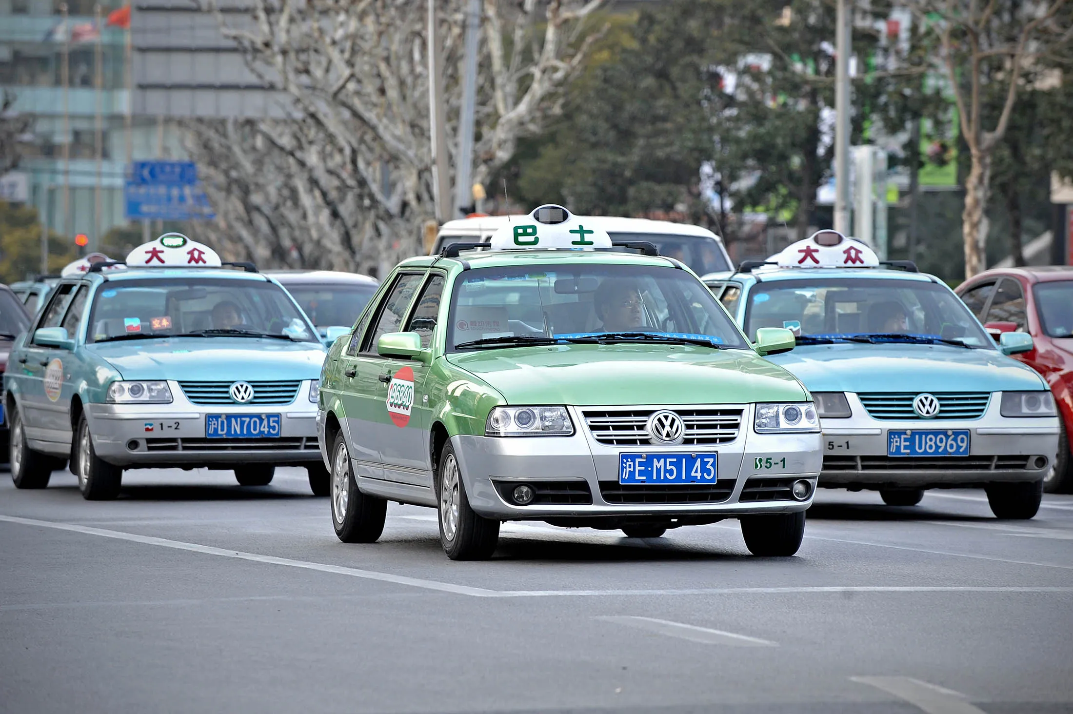Taxis wait for a traffic light to turn g