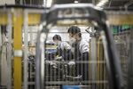 Employees wearing protective face masks work on a production line at a factory in Shanghai.