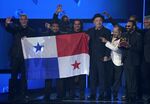 Ruben Blades, third from right, Roberto Delgado, right, and his orchestra accept the award for album of the year for &quot;Salswing!&quot; while holding up the flag of Panama at the 22nd annual Latin Grammy Awards on Thursday, Nov. 18, 2021, at the MGM Grand Garden Arena in Las Vegas. (AP Photo/Chris Pizzello)