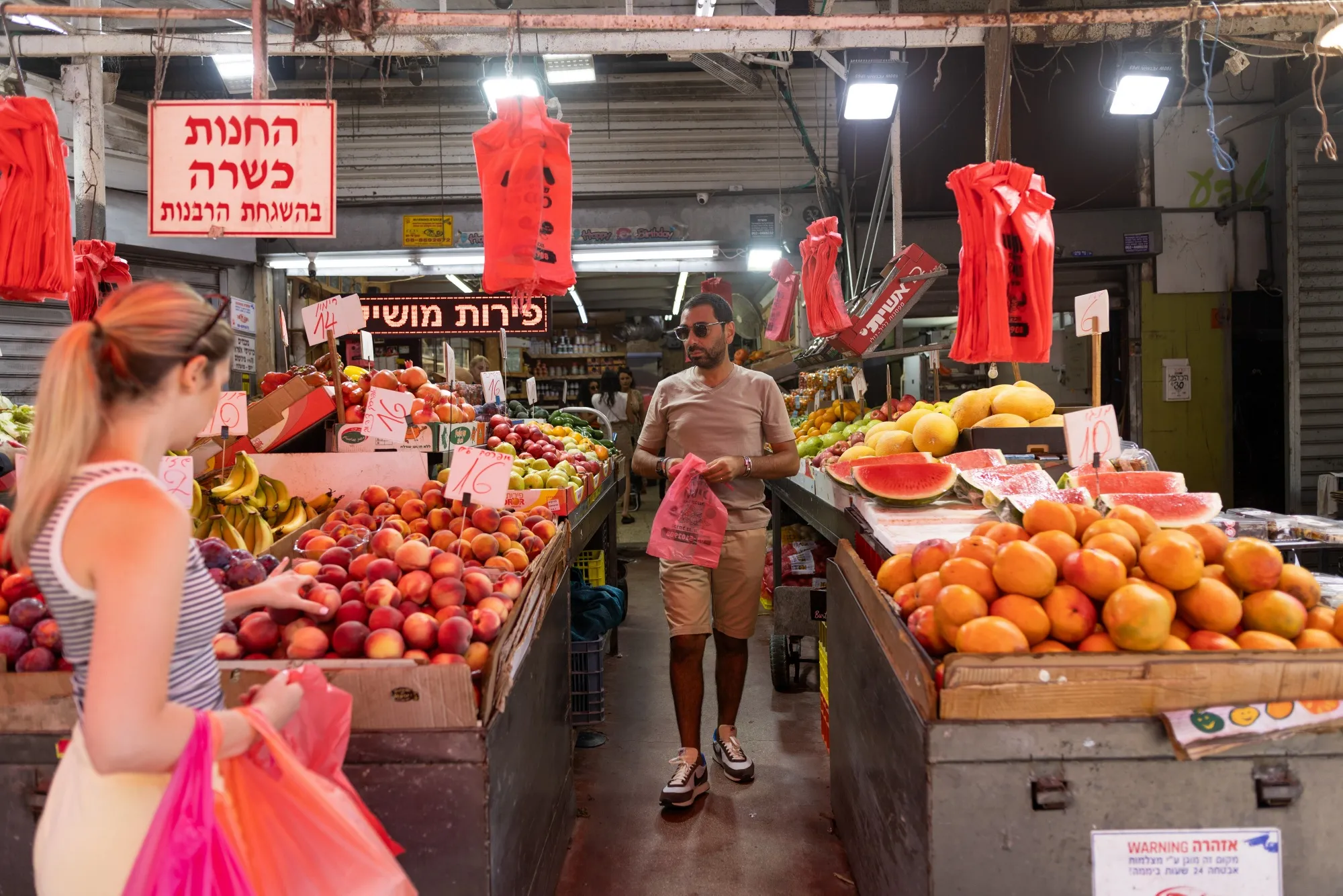 Customers shop at a fruit and vegetable store in&nbsp;Tel Aviv, Israel.