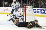Vegas Golden Knights right wing Reilly Smith (19) crashes to the ice after being tripped by Tampa Bay Lightning goaltender Andrei Vasilevskiy (88) during the second period of an NHL hockey game Tuesday, Dec. 21, 2021, in Las Vegas. (AP Photo/L.E. Baskow)